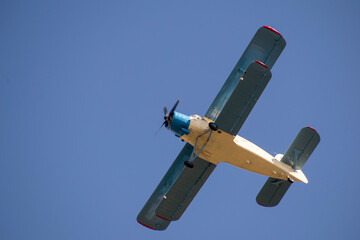 Old biplane in the sky in the clouds. Bottom view. Aerial concept.