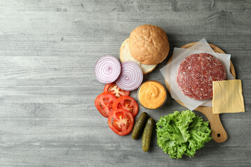 Concept of cooking burger on gray textured table