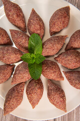 Traditional kebbe and pita bread on big round plate in lebanese restaurant. High quality photo