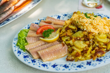Smoked Eel - Fish filet on a plate with fried potatoes from Germany, traditional dish from Bad Zwischenahn