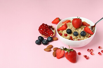 Concept of tasty eating with oatmeal on pink background
