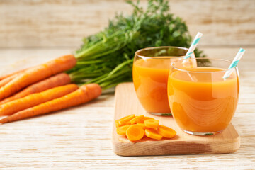 Fresh carrot smoothies and vegetables on a wooden table,close-up.