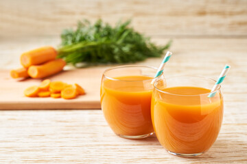 Fresh carrot smoothies and vegetables on a wooden table,close-up.