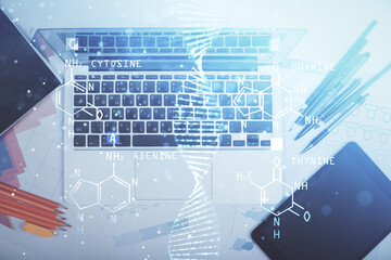DNA hologram drawings over computer on the desktop background. Top view. Multi exposure. Concept medical education.