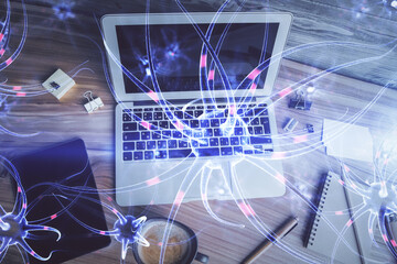 Neuron hologram drawings over computer on the desktop background. Top view. Multi exposure. Concept of education.