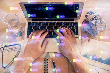 Double exposure of man's hands typing over computer keyboard and data theme hologram drawing. Top view. Technology concept.