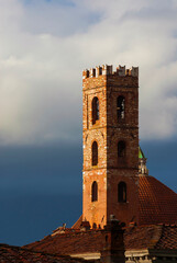 Church of Ss John and Reparata ancient belfry in the shape of medieval tower with cloudy sky