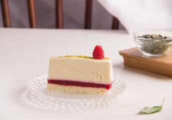 Dessert sweet cheesecake with raspberry jam on a white plate. Copy space