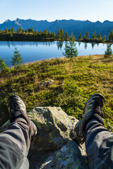 Legs of a hiker relaxing and enjoying the view in the mountains.