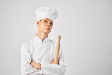 a man in a chef's form of a bell in the hands of a professional work light background