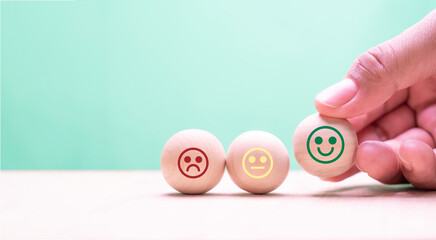 world mental health day, a hand man arranging a happy smiley face on wooden ball for good feedback...