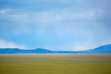 Panoramic view of mountains in the distance, blue clouds over mountains, cyclone, storm warning.
