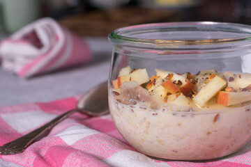 Overnight oats with fresh apples and linsseeds in a jar with spoon