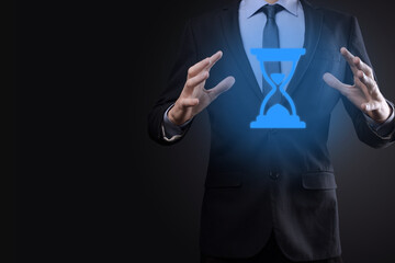 Businessman man holds in hand hourglasses icon. Time expires. A reminder to action. Business concept. Elements for design.