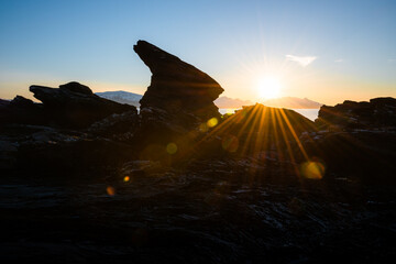Distinctive rock formation at a fjord landscape in northern Norway on a warm summer evening with midnight sun