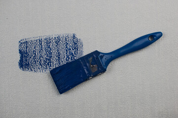 paintbrush painting, Worker painting on surface wall painting apartment, renovating with dark blue...