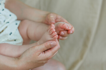 Close-up of baby's feet in mom's. Baby. Home. Cozy.