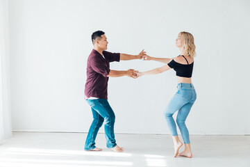 Naklejka premium a man and a woman dance bachata music in a white room
