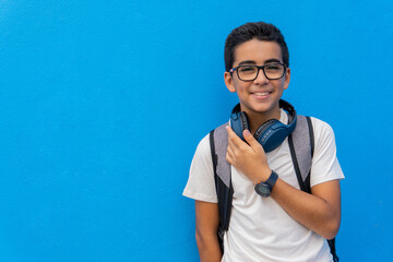 Pre-adolescent in front of a blue school wall