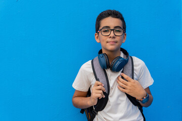 Pre-adolescent in front of a blue school wall