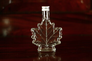 A clear glass bottle shaped like a leaf.