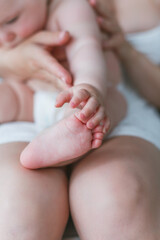 Obraz na płótnie Canvas Close-up of baby's feet in mom's. Baby. Home. Cozy.