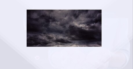 Digitally generated image of dark clouds against white technology background