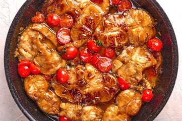 Traditional Sicilian fish with tomatoes and spices in in the pan. Food background, close up