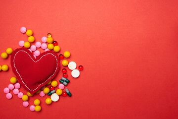 multicolored pills soft heart red background health treatment