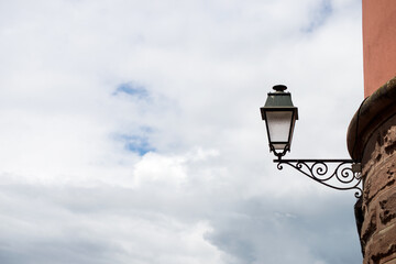 Closeup of vintage street light in the street on cloudy sky background