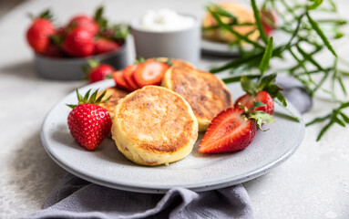Cottage cheese pancakes or fritters with strawberry and natural yogurt. Healthy breakfast or lunch. Syrniki.