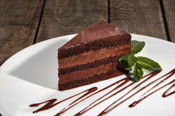 Slice of chocolate sponge cake with buttercream and chocolate ganache