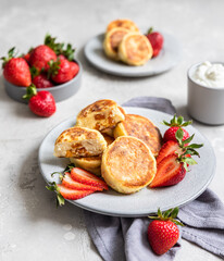 Cottage cheese pancakes or fritters with strawberry and natural yogurt. Healthy breakfast or lunch. Syrniki.