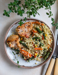 Baked chicken or turkey breast with bulgur and vegetables on a plate. Top view.