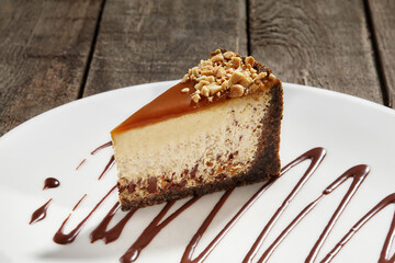 Slice of cheesecake with chocolate, nuts and caramel on shortcrust pastry
