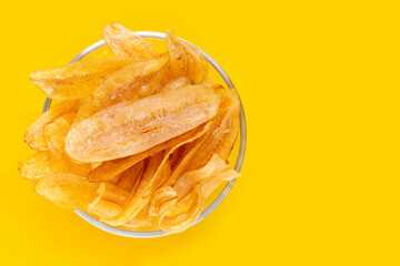 Banana slice chips on yellow background.