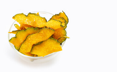 Green pumpkin slice chips in glass bowl on white background.