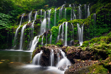 Obraz premium Waterfall landscape. Beautiful hidden waterfall in tropical rainforest. Nature background. Slow shutter speed, motion photography. Banyu Wana Amertha waterfall, Bali, Indonesia