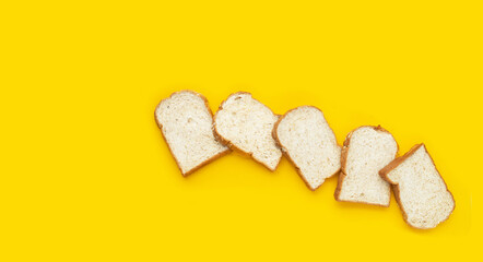 Sliced wholegrain bread on yellow background.