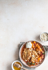 Ceramic plate with tasty plum crumble dessert served with vanilla ice cream and herbs. Top view.