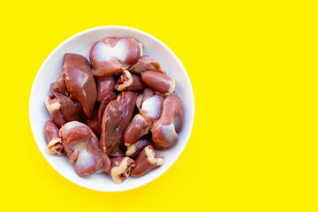 Mixed chicken entrails in white plate on yellow background.