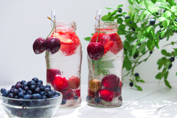 Fototapeta na wymiar Variety of fruit with detox water in glass small bottles. Refreshing summer drinks. Healthy diet concept.