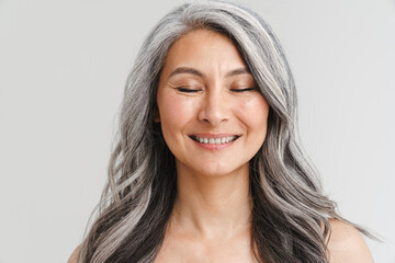 Fototapeta premium Mature shirtless woman with her eyes closed smiling at camera