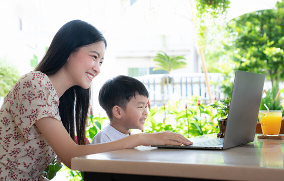 Oung Asian Mother And Son Using Laptop Computer For Study And Learning Together At Home