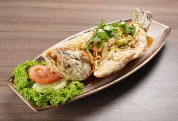 deep fried crispy whole grouper fish with mango salad dressing on wood background asian halal menu