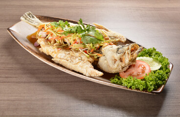 deep fried crispy whole grouper fish with mango salad dressing on wood background asian halal menu