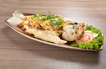 deep fried crispy whole grouper fish with mango salad dressing on wood background asian halal menu