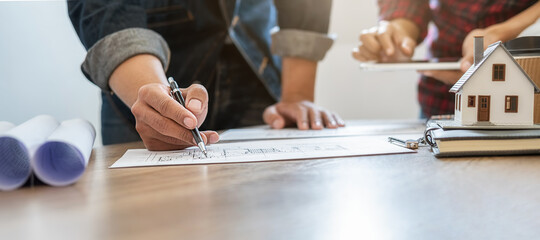 Engineer or architect teamwork working on construction project with building model and blueprint in office. Construction concept.