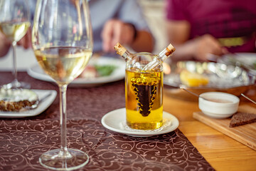 Glass on a high thin leg with white wine on the table in a restaurant