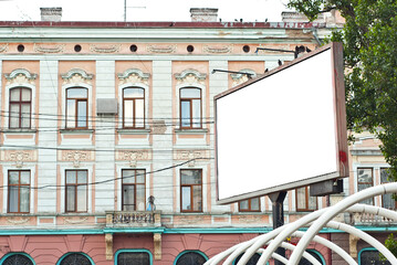 Blank billboard on house background. Old architecture in the background. Copy space and space for text. Mockup for design. Blank template for advertising.